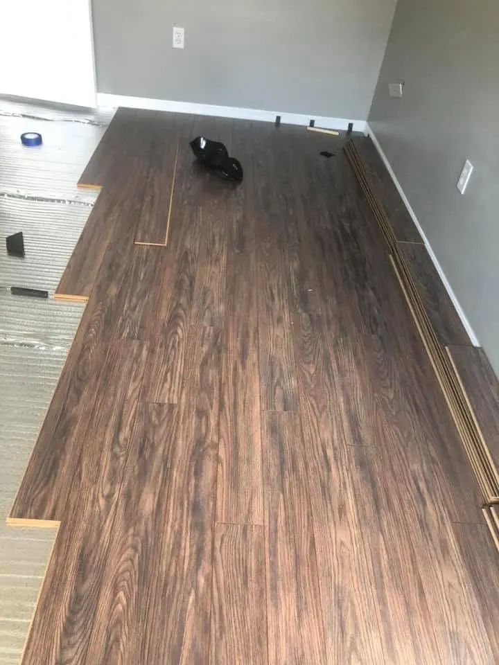 Dark laminate flooring being installed by PalmPro